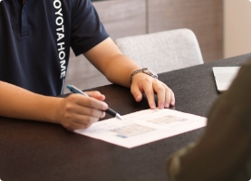 住宅担当者が図面を指しながら顧客に説明している様子