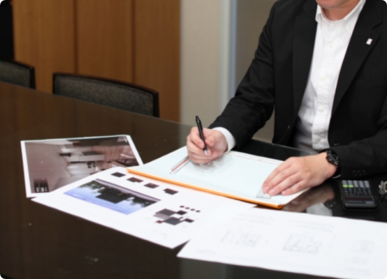 住宅プランの資料を見ながら打ち合わせを行うスタッフ