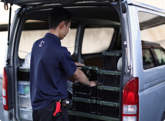 作業車の荷台で工具を整理する現場スタッフ