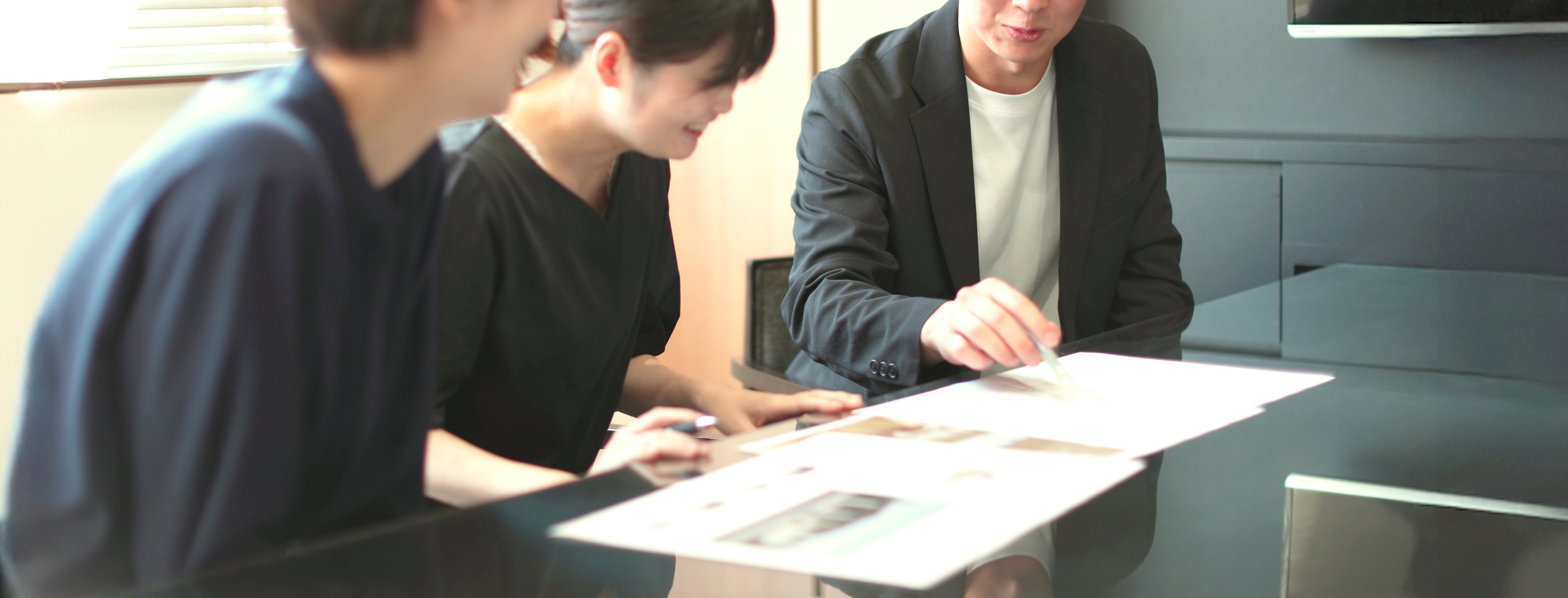 住宅担当者がカップルに明るいリビングを案内している様子