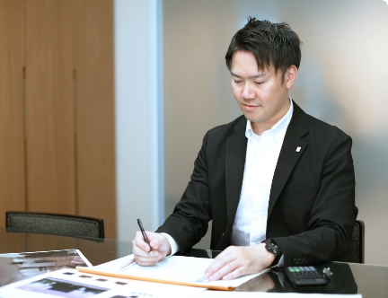 資料を受け取りながら打ち合わせをする社員